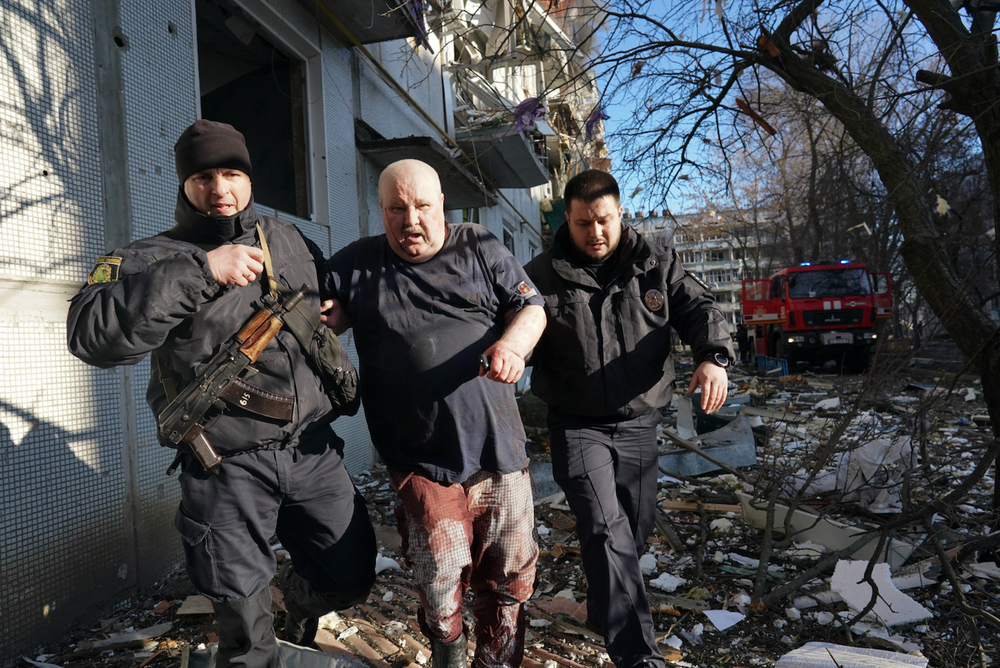 Ukrainian security forces accompany a wounded man after an airstrike hit an apartment complex in Chuhuiv, Kharkiv Oblast, Ukraine on February 24, 2022. Wolfgang Schwan - Anadolu Agency